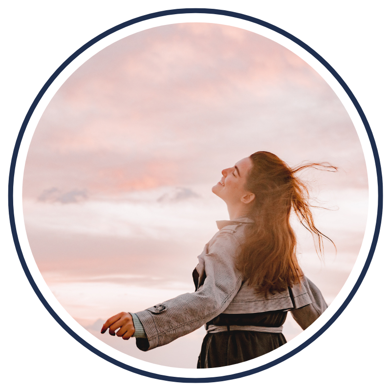 A young woman smiling with her eyes closed enjoying the sun and air