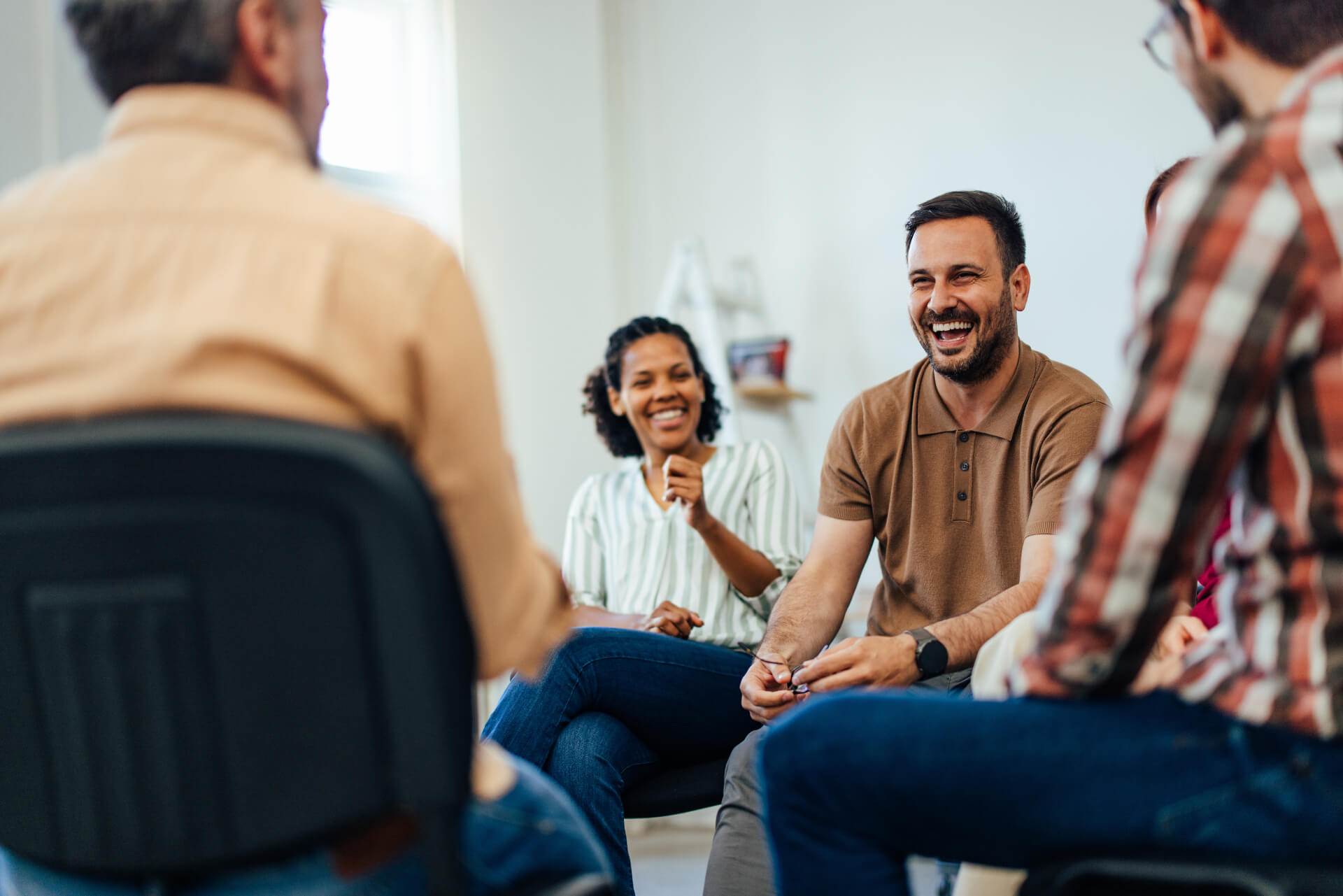 An addiction treatment group therapy session with man smiling