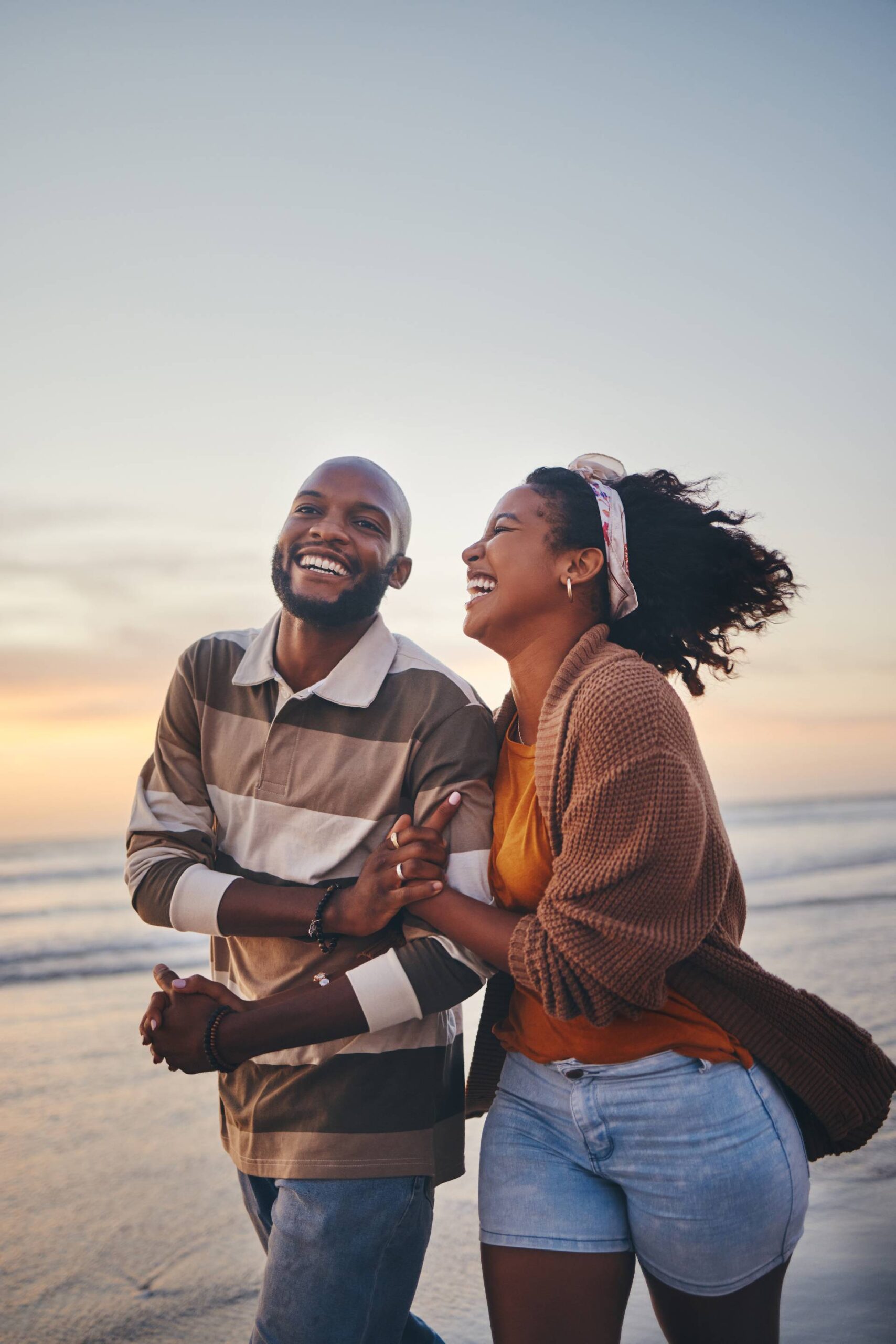 A young couple looking very happy walking on the beach