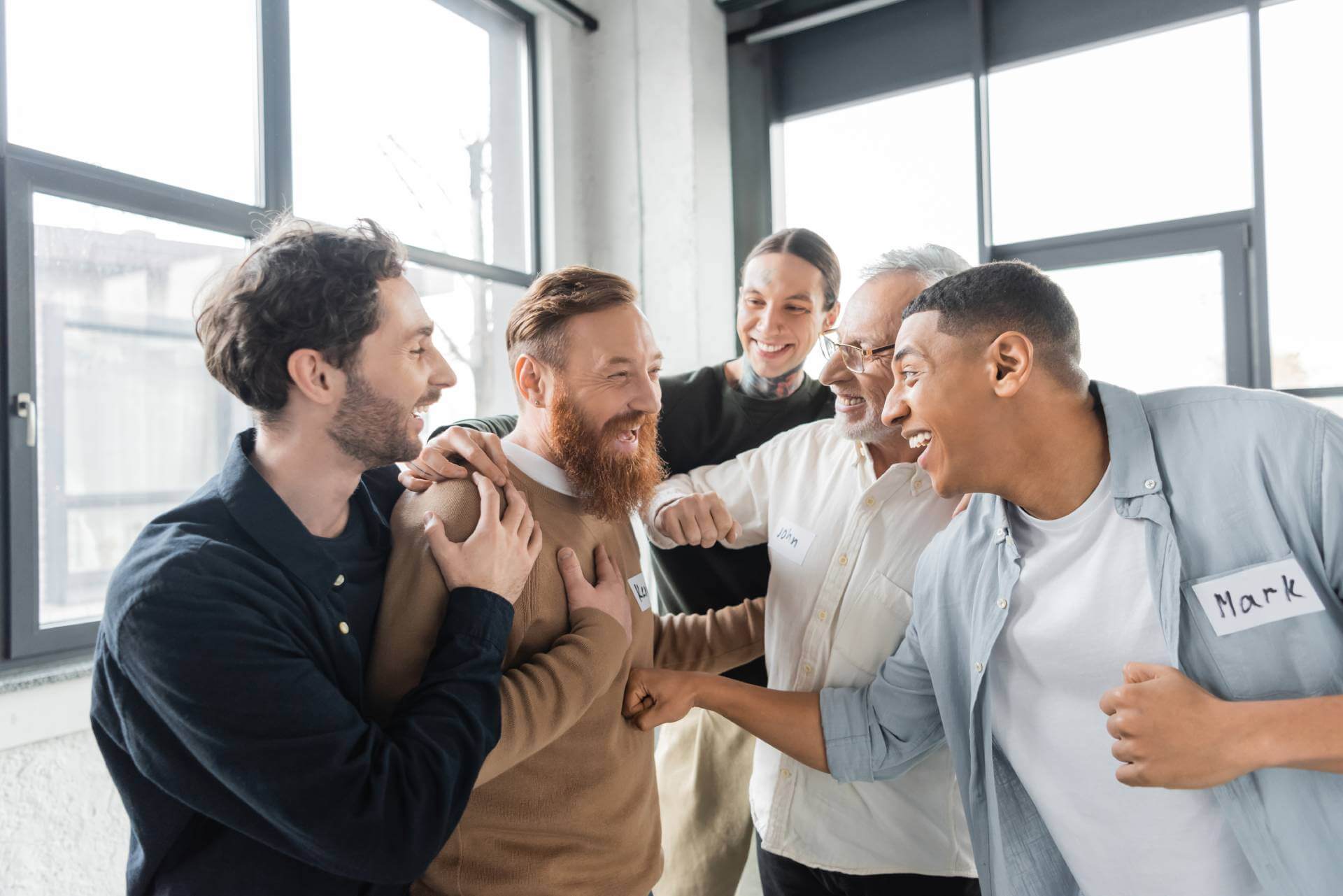 People in an addiction treatment group therapy session congratulating one of the members